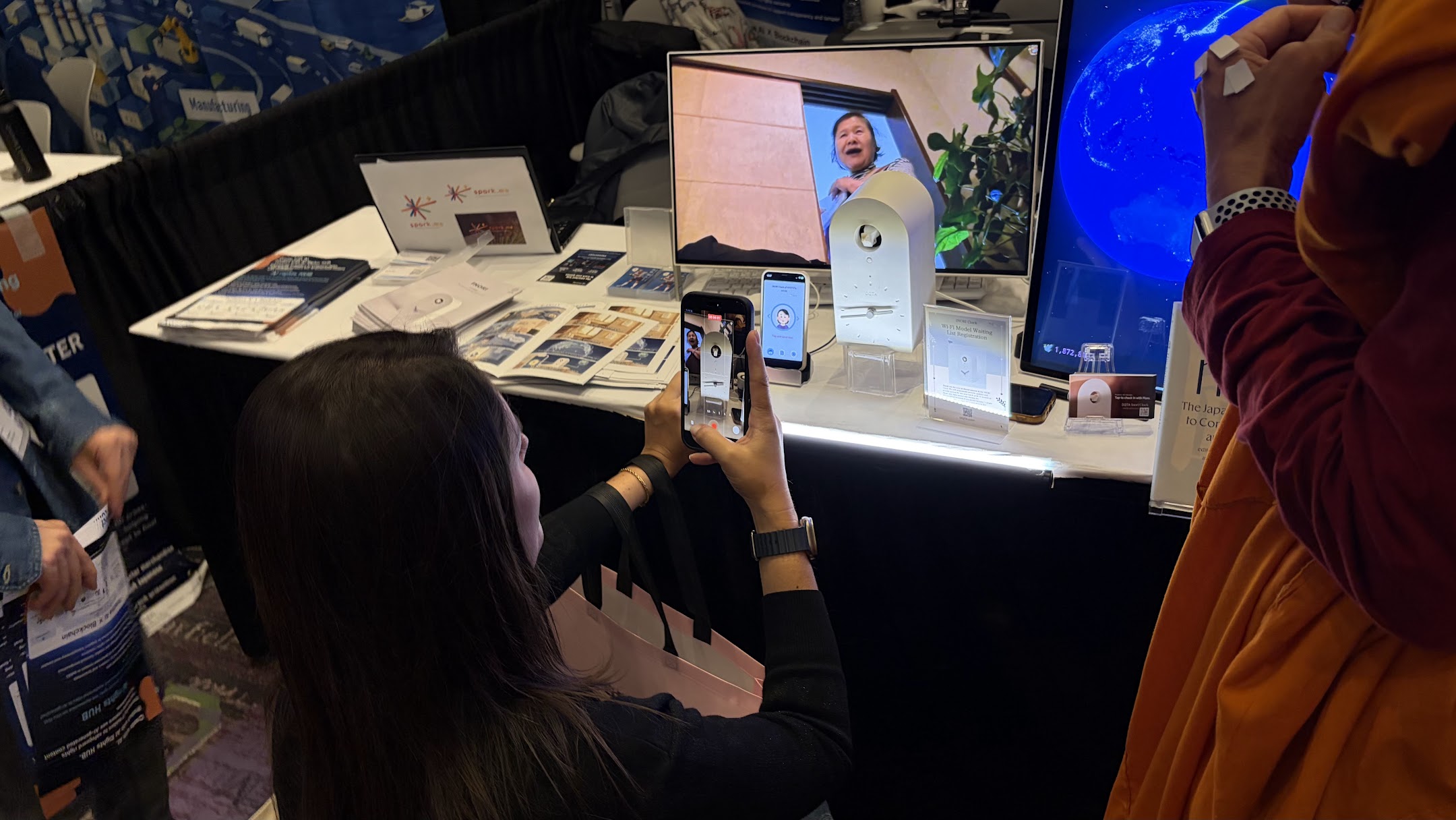 INORI Clockの実機と画面を来場者が撮影している様子